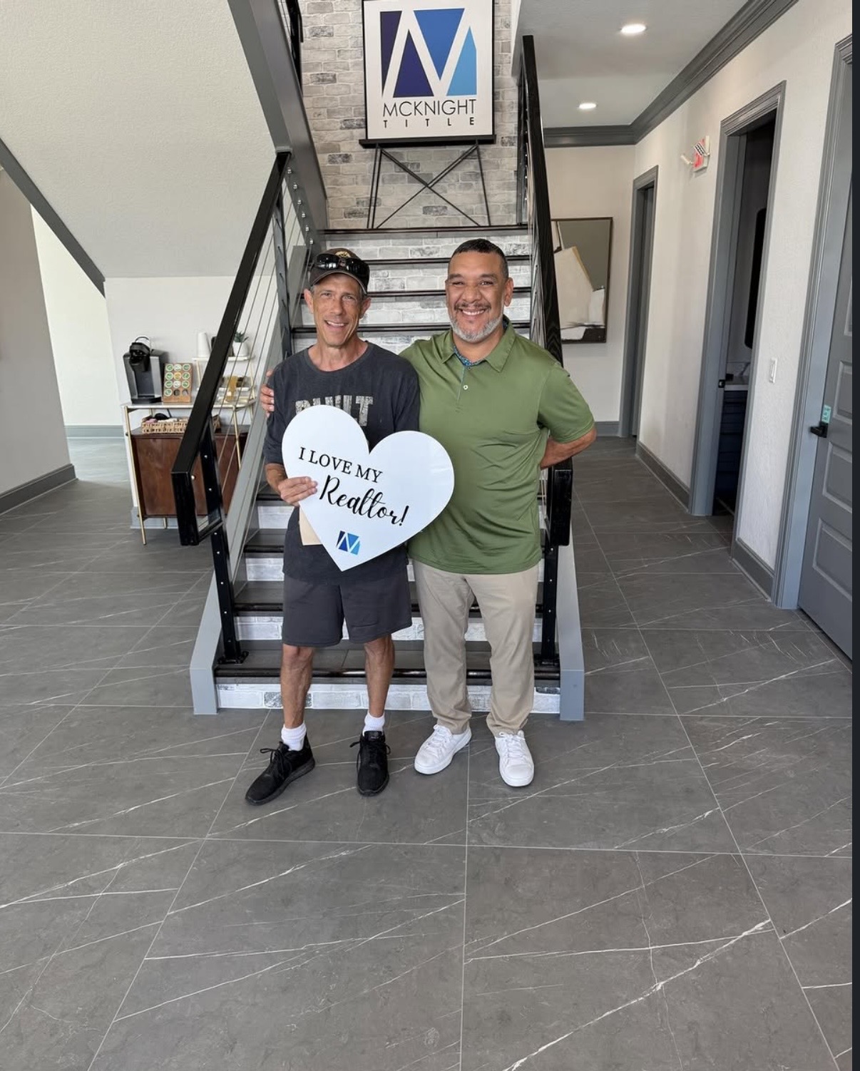 Samuel Westry with a client holding an 'I Love My Realtor' heart sign after closing