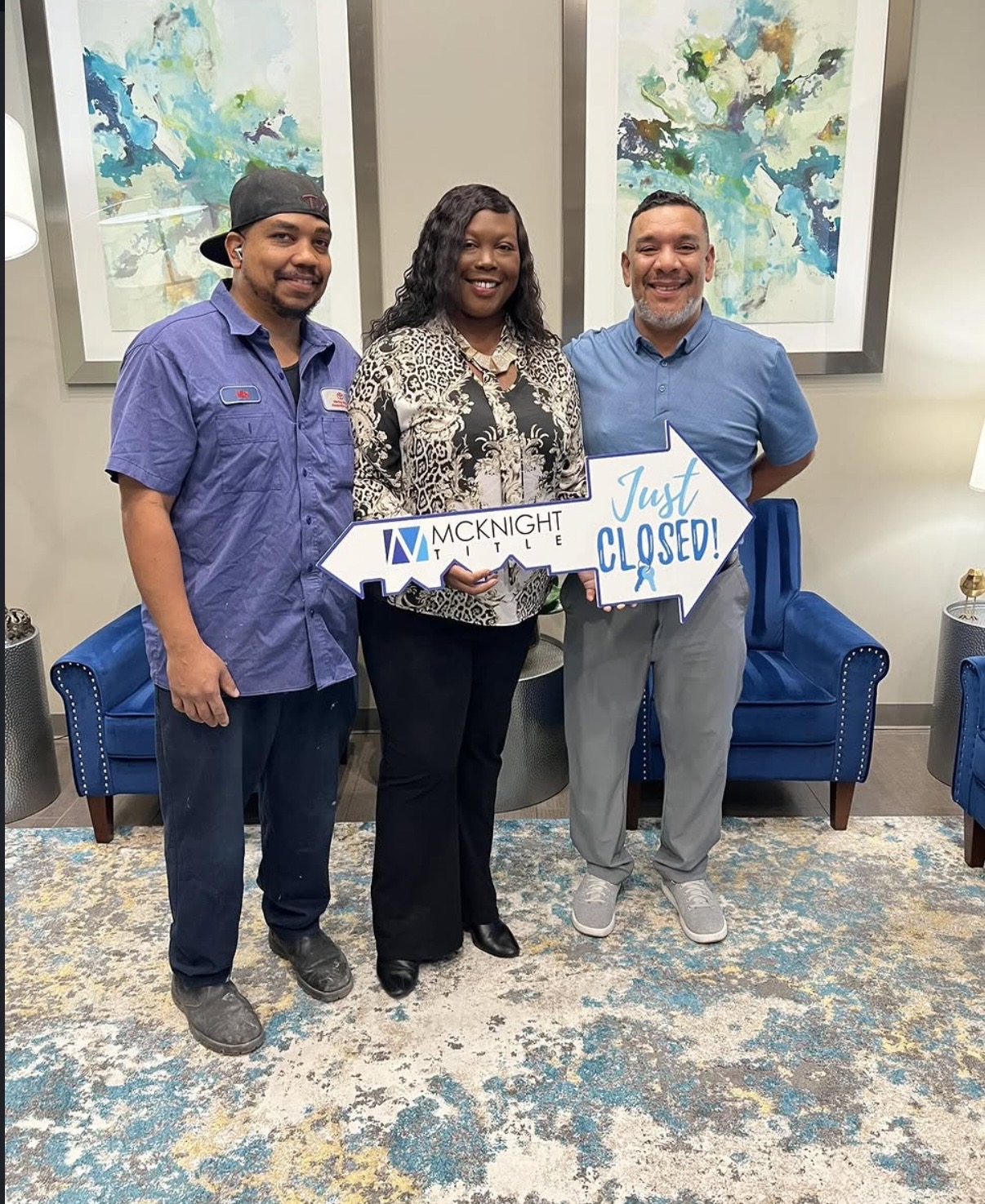 Samuel Westry at McKnight Title with clients Mike and Ernestine holding a Just Closed sign